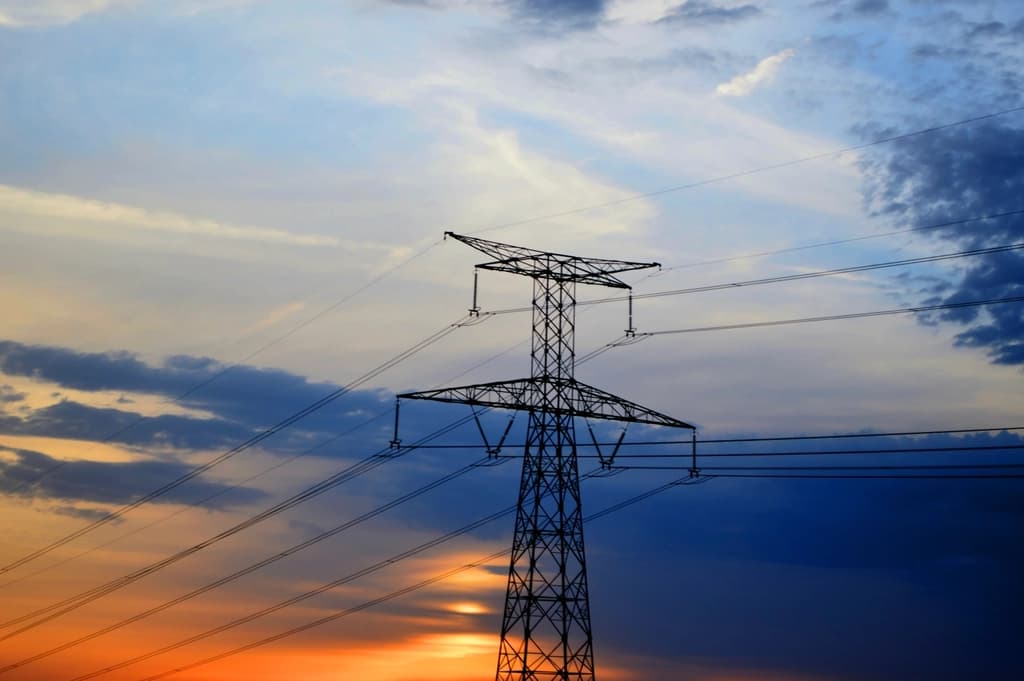 Electricity transmission pylons against a sunset sky